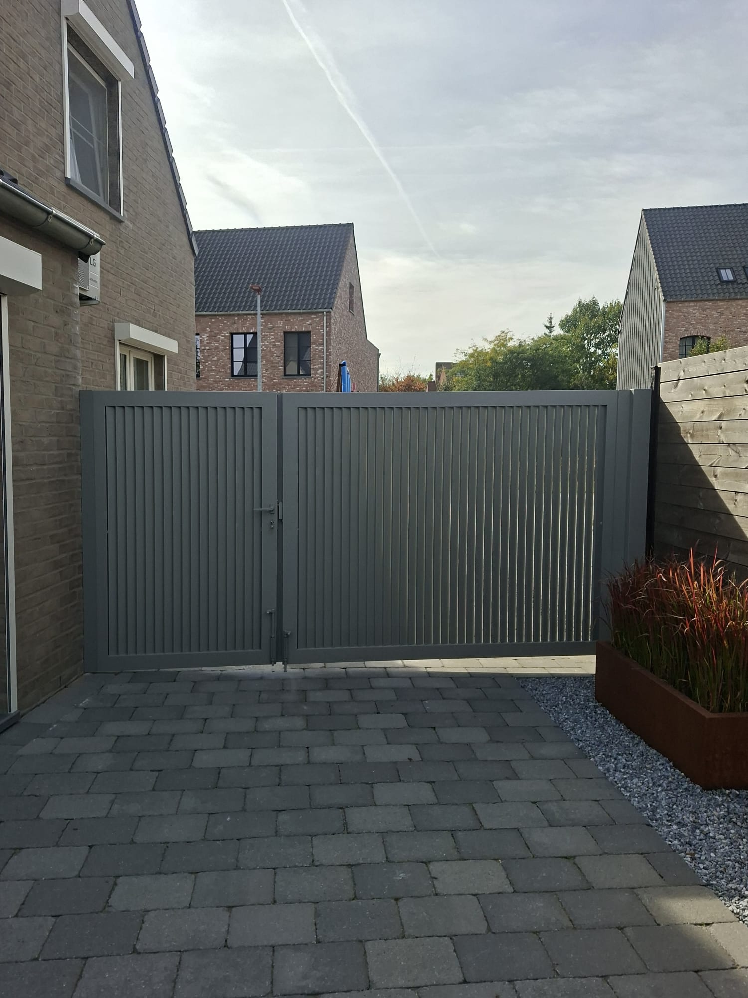 Grijze draaipoort met verticale lamellen