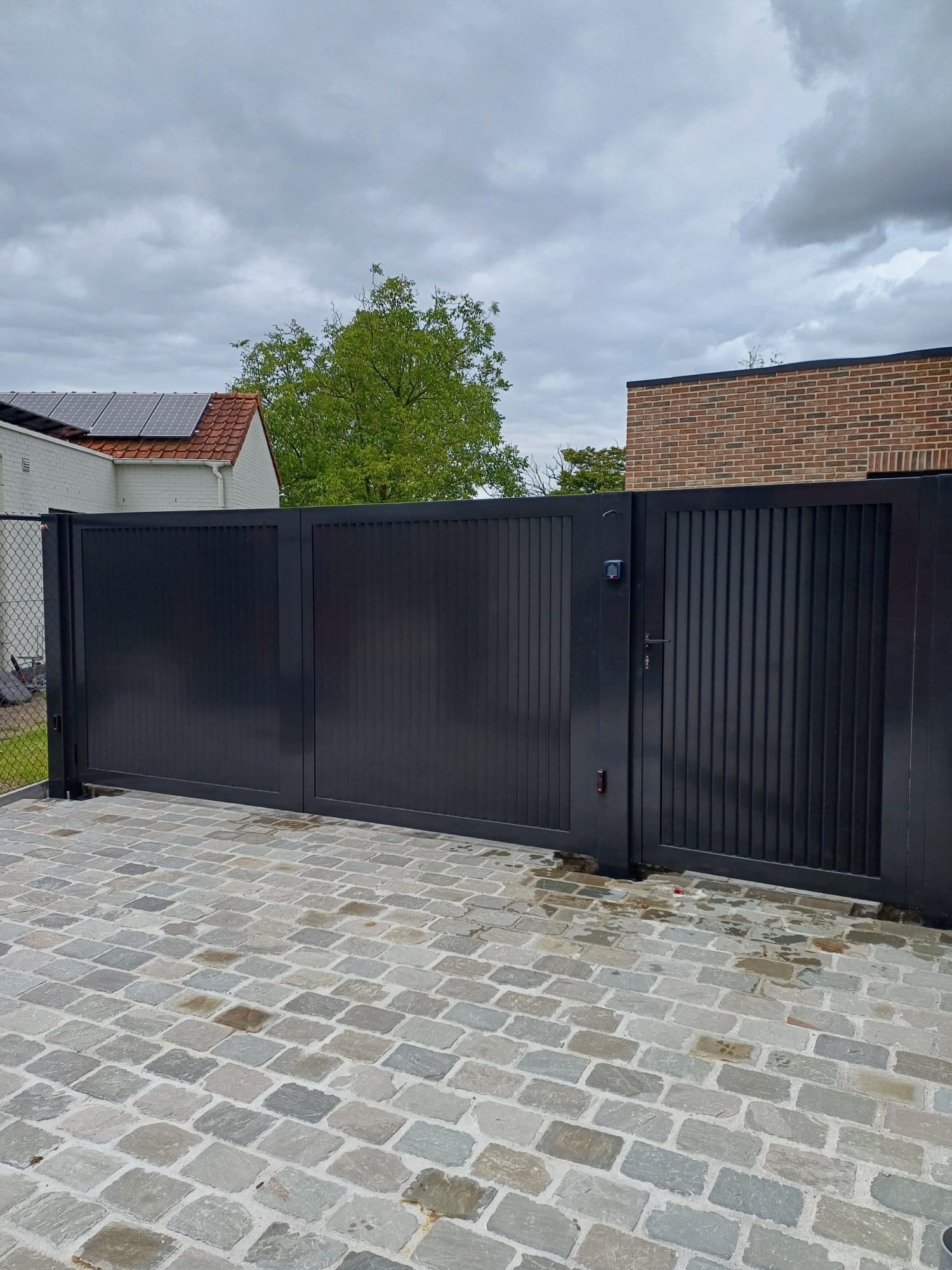 Zwarte draaipoort met verticale lamellen