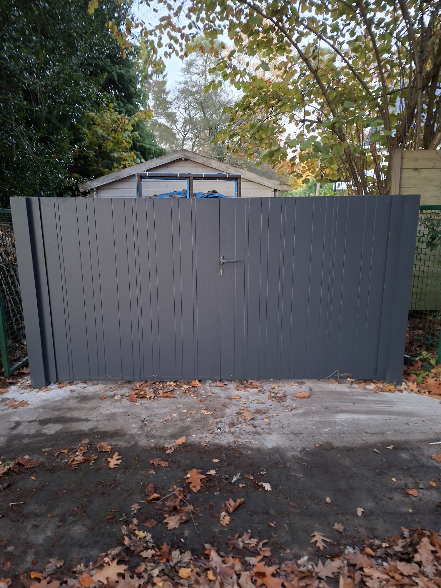 Antraciet verticale poort met herfstblad